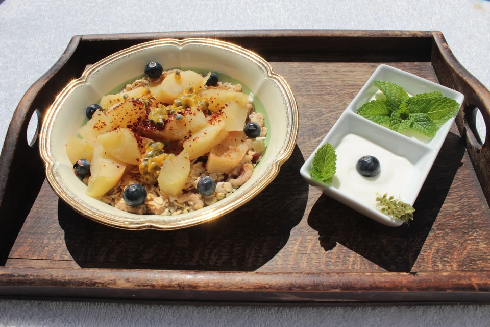 A breakfast tray of bircher muesli with poached pear, passionfruit and blueberries